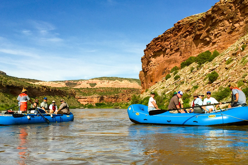 A group of people in boats rafting down the Colorado River in Fruita, Colorado