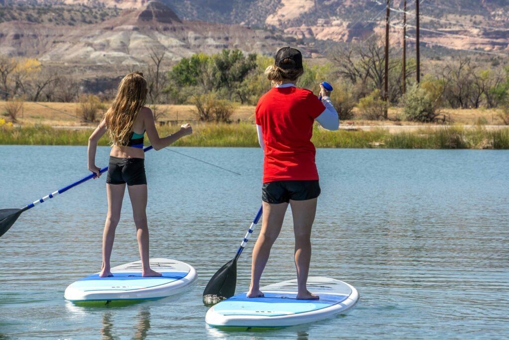 Two girls paddle boarding.
