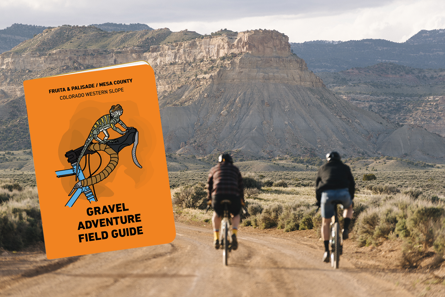 Two bikers riding towards a mountain with a book cover on the left hand side.