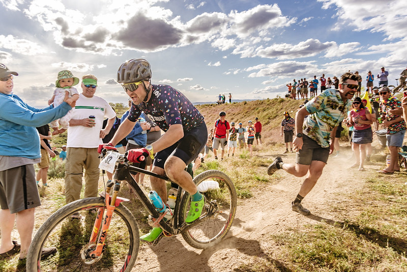 A mountain biker is surrounded by a crowd at the 18 Hours of Fruita event.