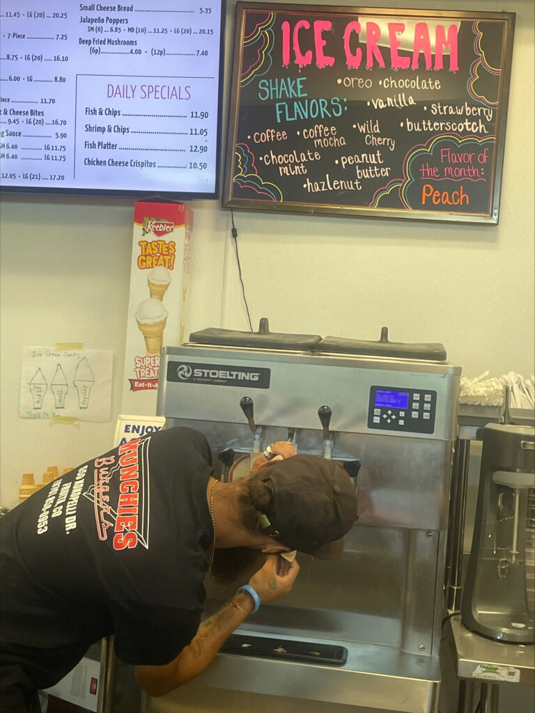 An employee prepares an ice cream cone at Munchie's.