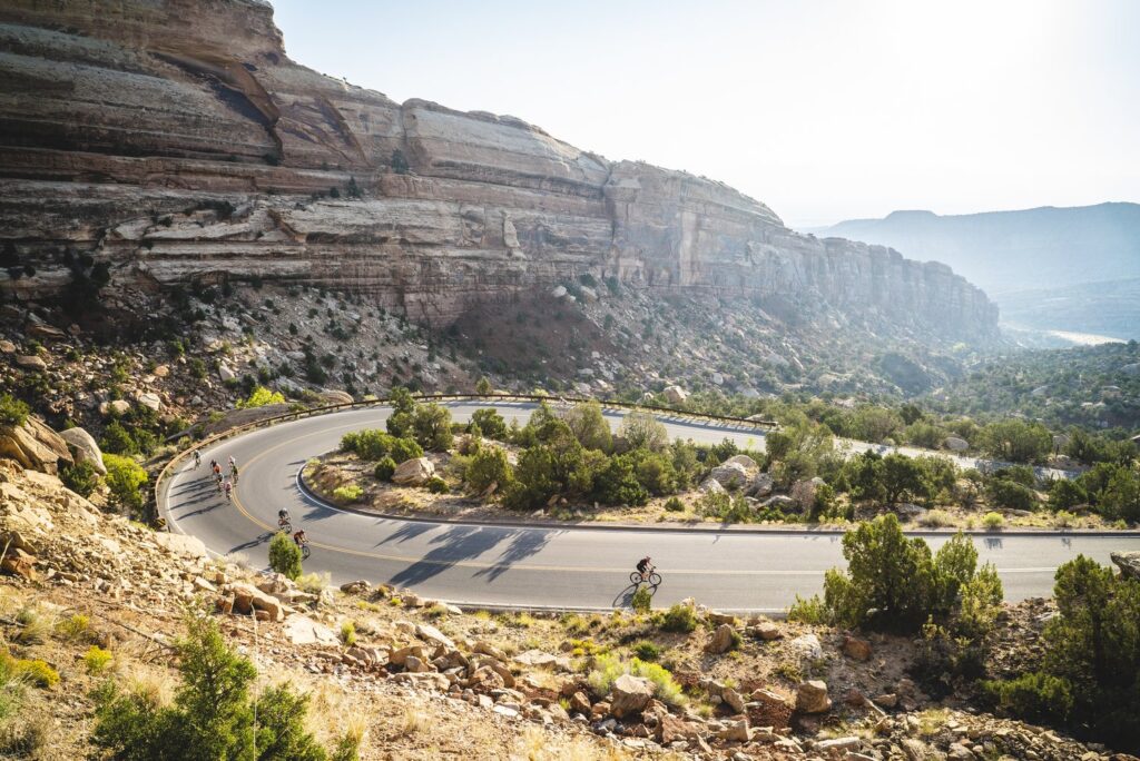 A picture of The Colorado National Monument with bicyclists on the road.