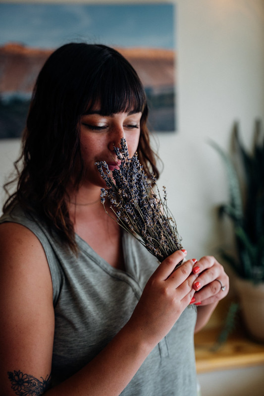 A woman smells lavender.