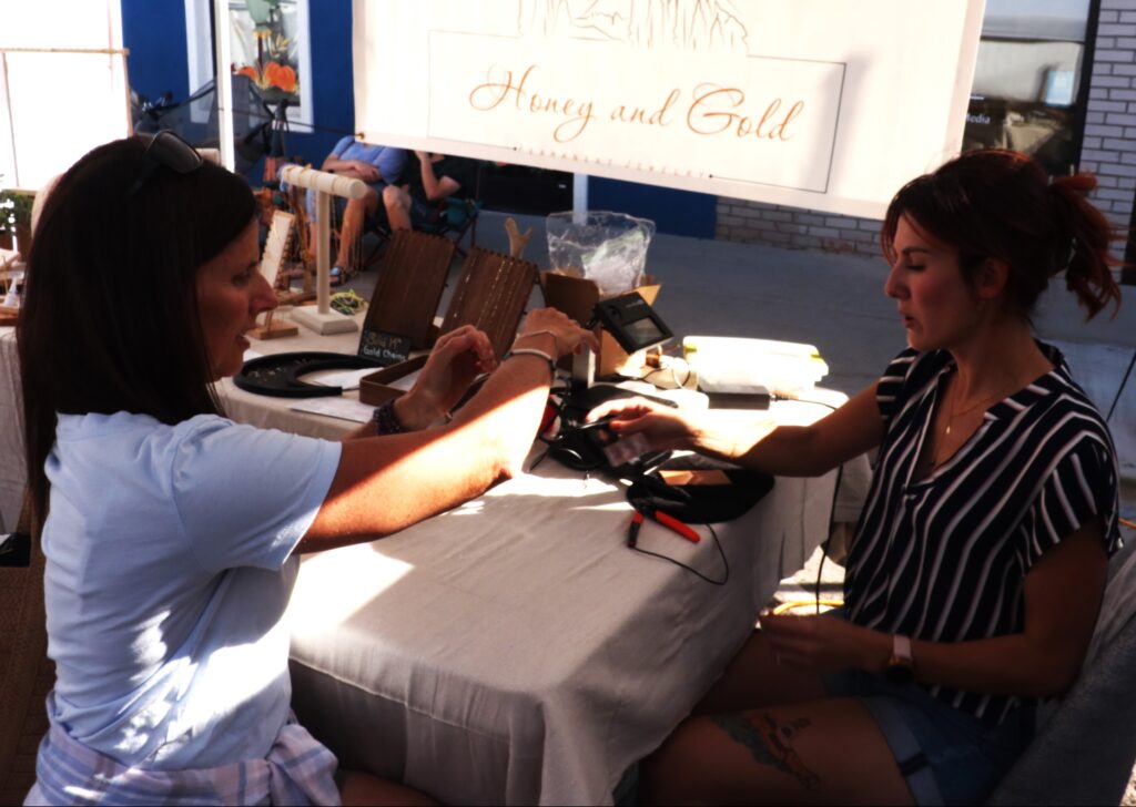 Two ladies sitting by a table. 