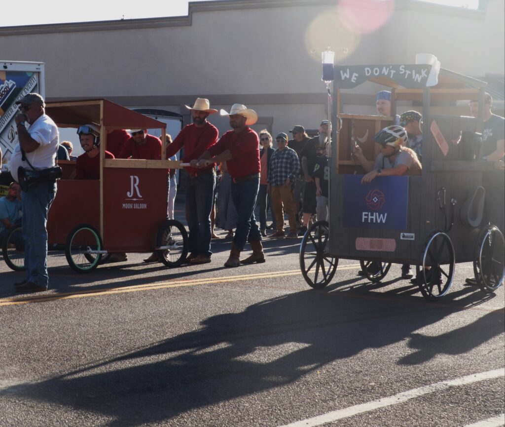 Two teams get ready to race in their outhouses on wheels.