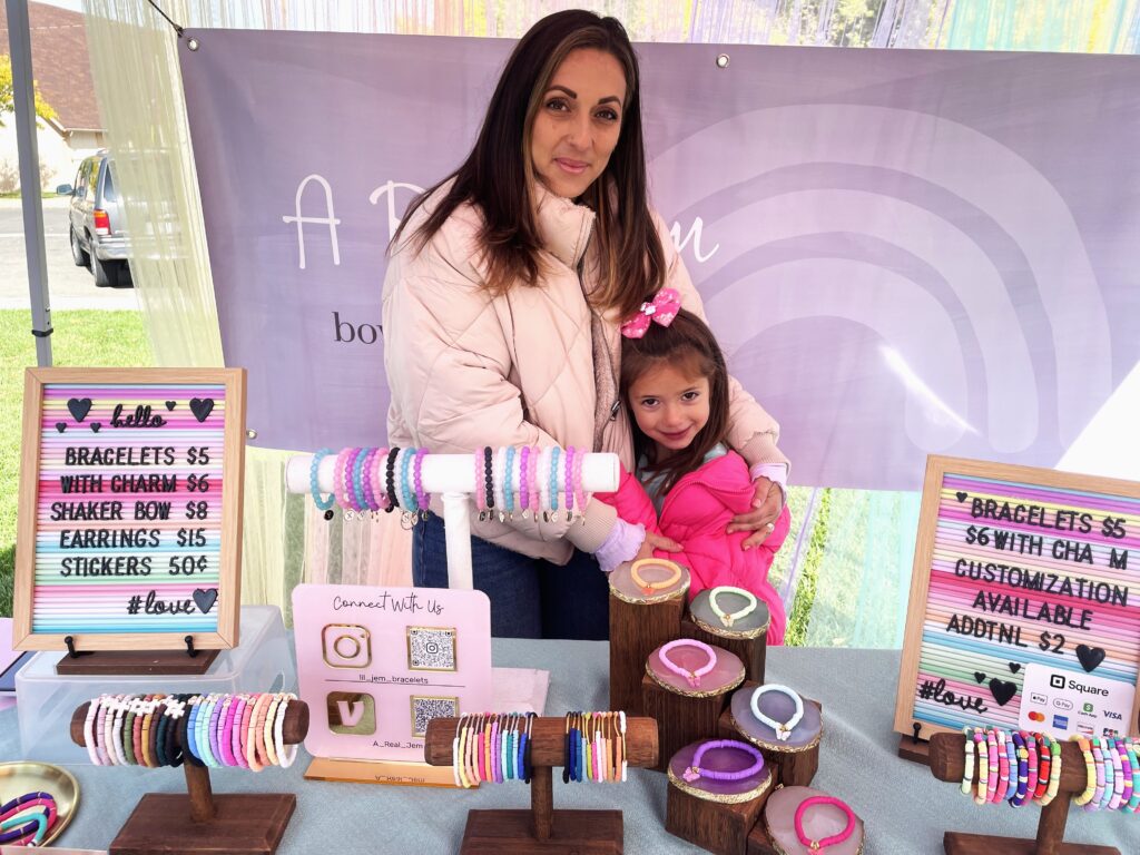 A mom and daughter sell bows and jewelry at the Fruita Farmers Market.