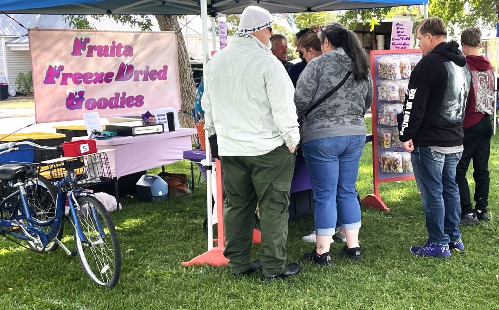 A group of five check out the Fruita Freeze Dried Goodies booth at the Fruita Farmers Market.