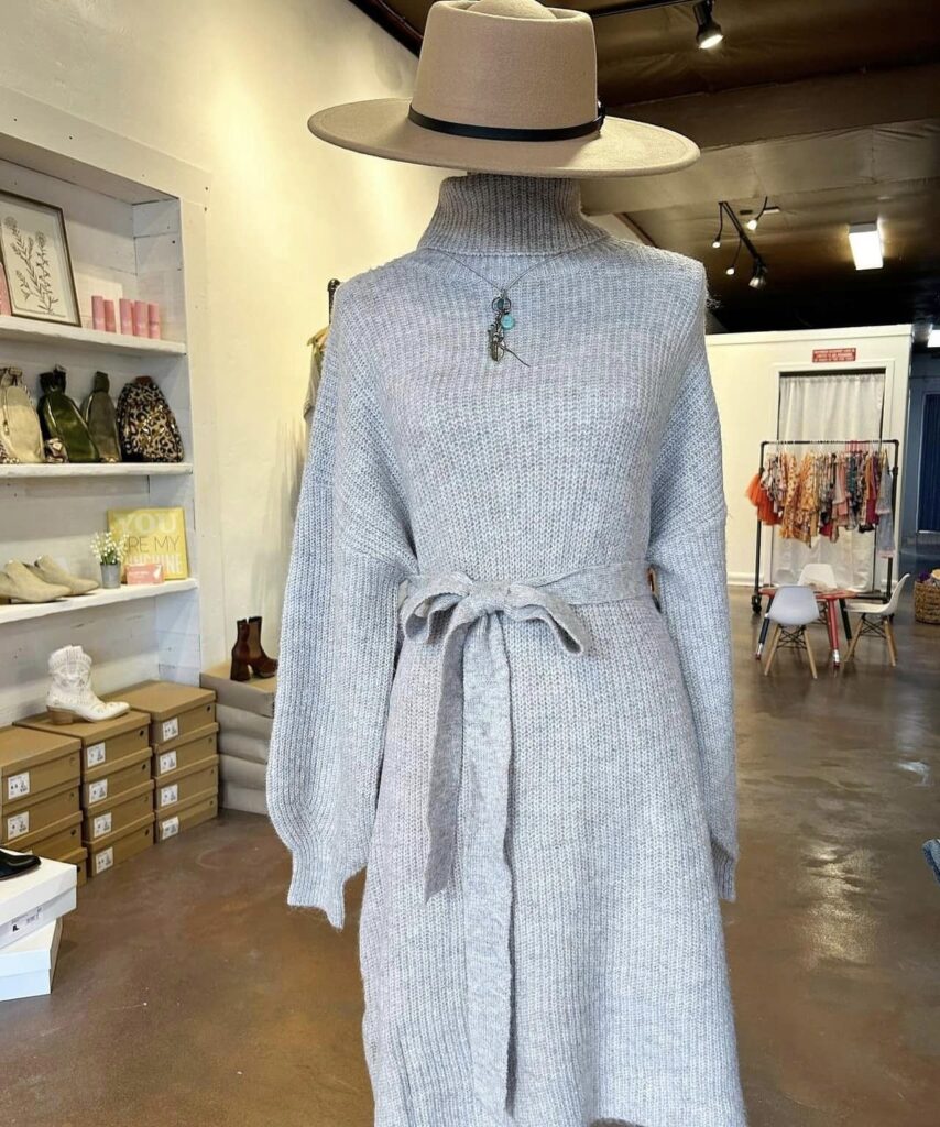A mannequin styled with a gray dress and a brown hat.