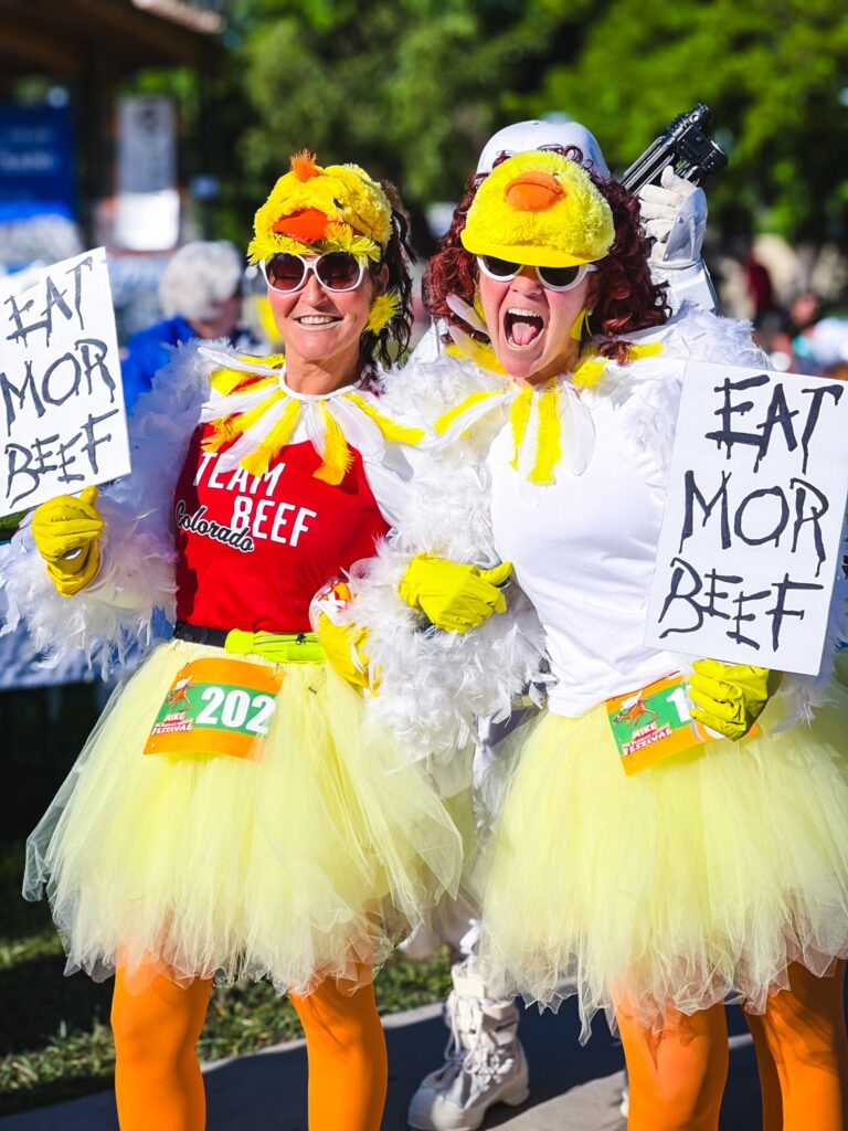 Two women in chicken costumes running in a 5k.