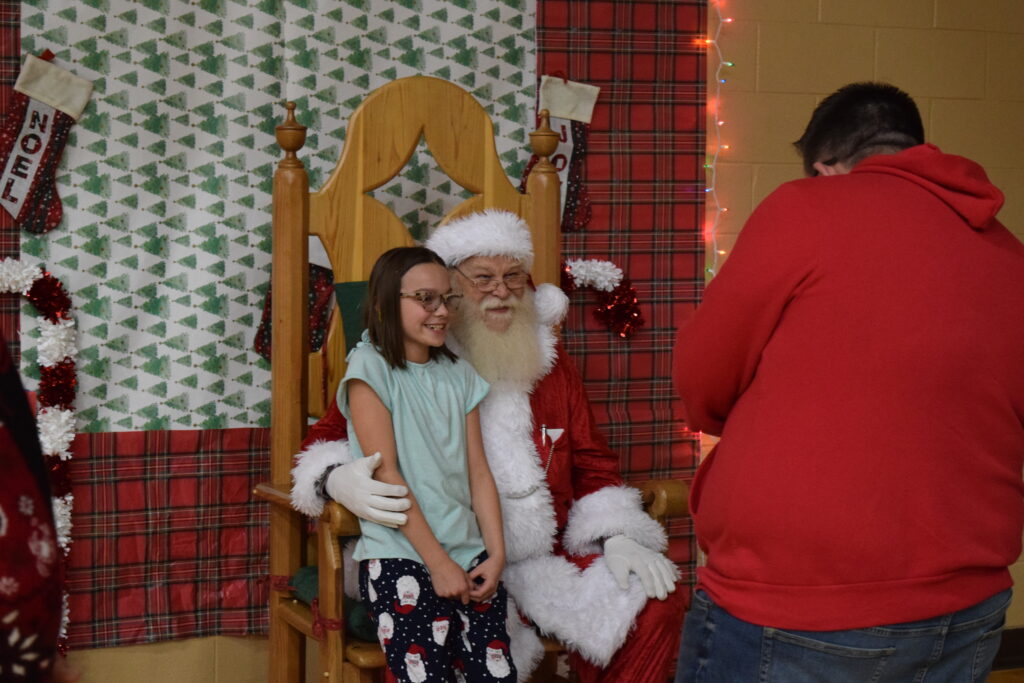 A child sitting on Santa's lap.