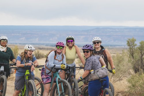 A group of women riding their bikes.